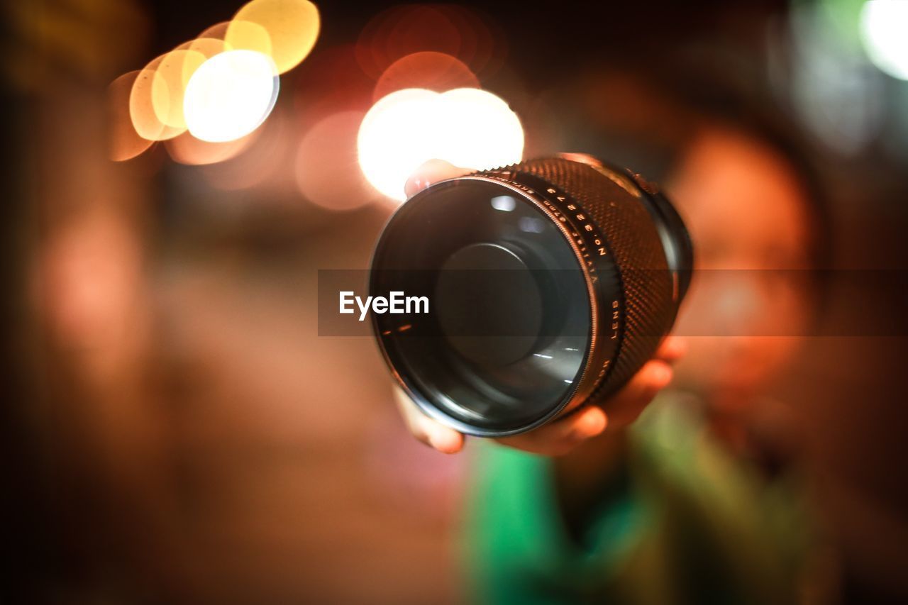 Close-up of hand holding camera lens