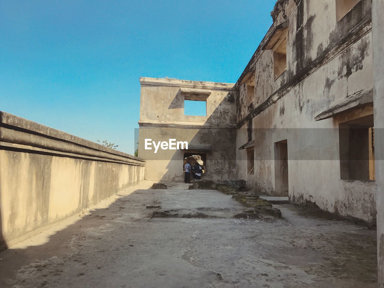 ALLEY AMIDST OLD BUILDINGS AGAINST CLEAR SKY