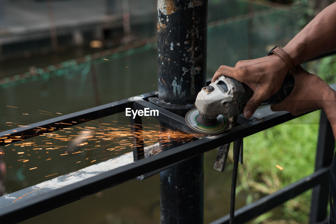 Cropped hands of person working on metal