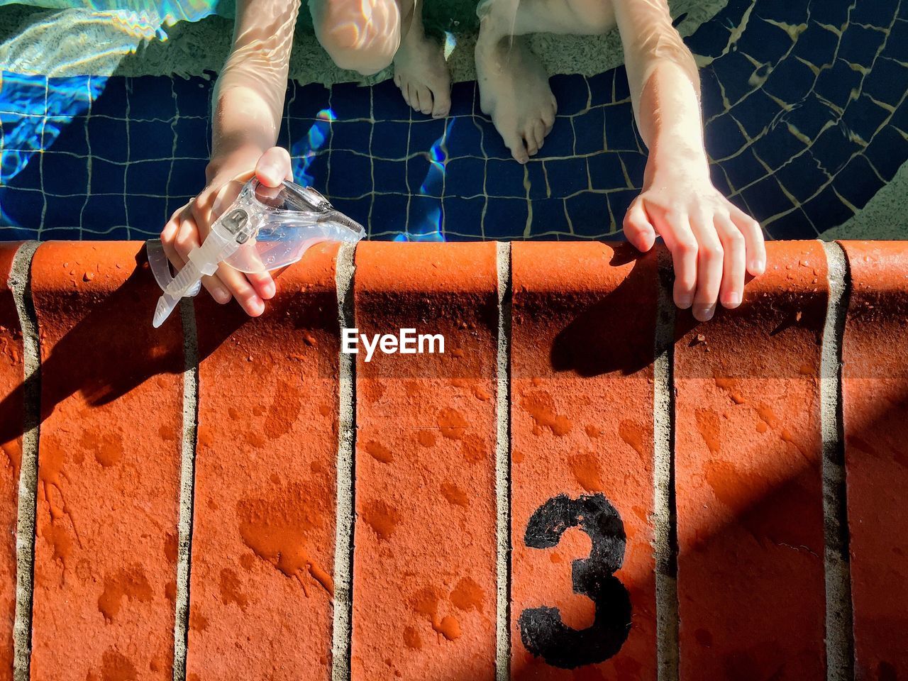 Close-up of hands on swimming pool