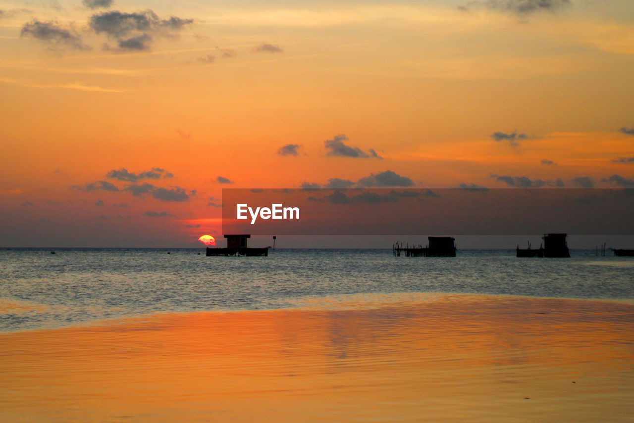 Scenic view of sea against orange sky