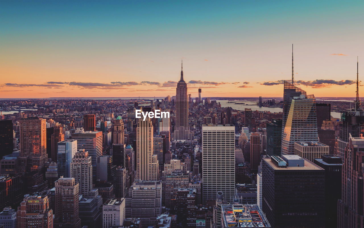 Aerial view of buildings in city during sunset