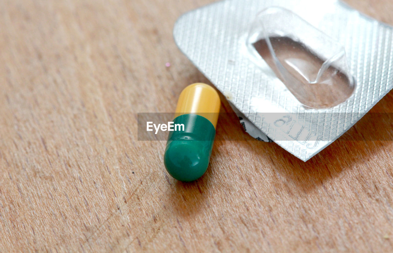 High angle view of capsule on wooden table