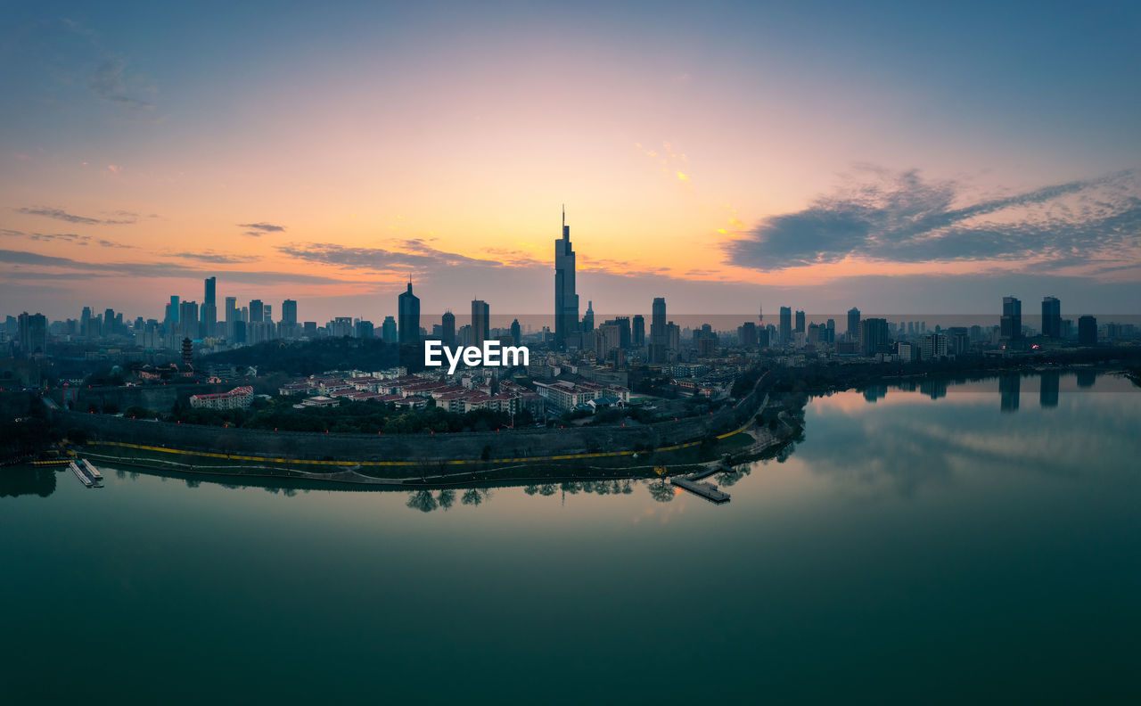 PANORAMIC VIEW OF BUILDINGS AGAINST SKY AT SUNSET