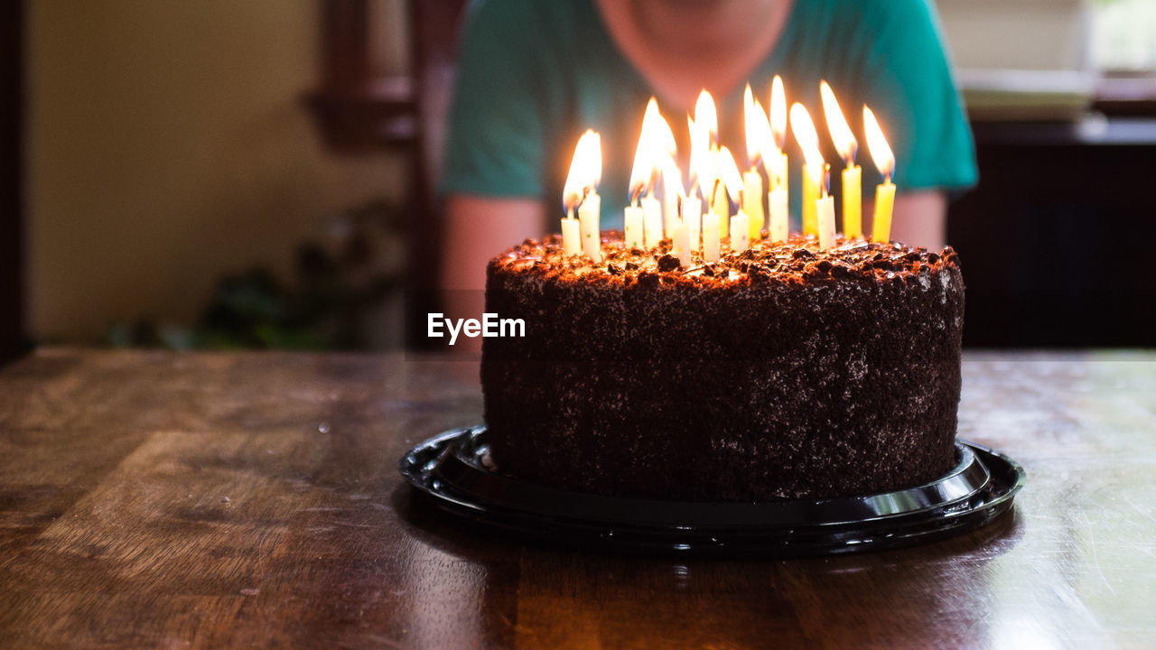 Close-up of illuminated candles on birthday cake