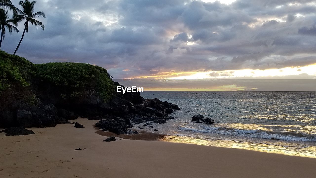 Scenic view of beach against sky during sunset