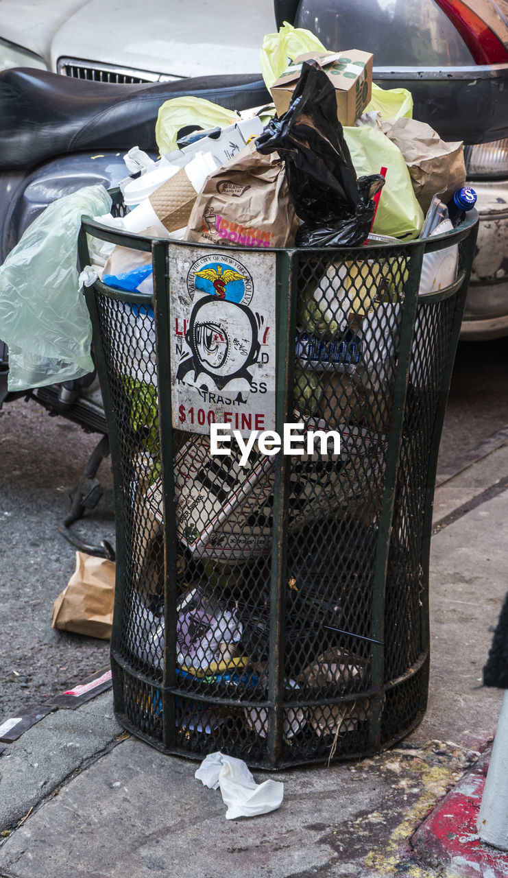 CLOSE-UP OF GARBAGE BIN AGAINST WALL