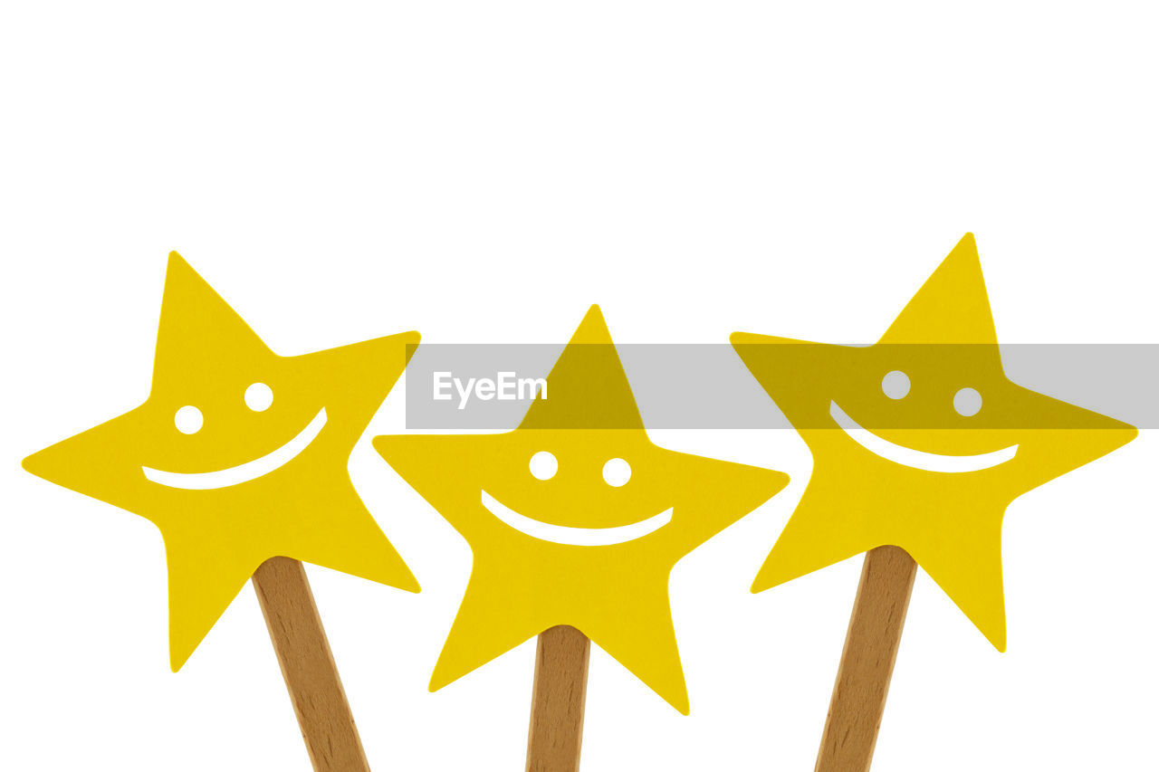 CLOSE-UP OF YELLOW FLAG AGAINST GRAY BACKGROUND