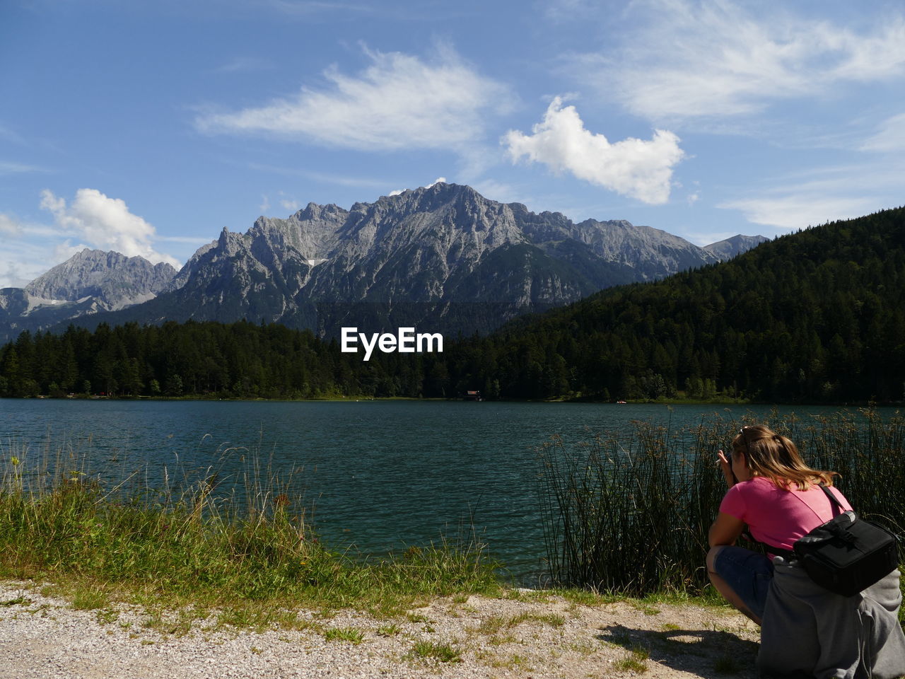 REAR VIEW OF WOMEN LOOKING AT LAKE AGAINST MOUNTAIN