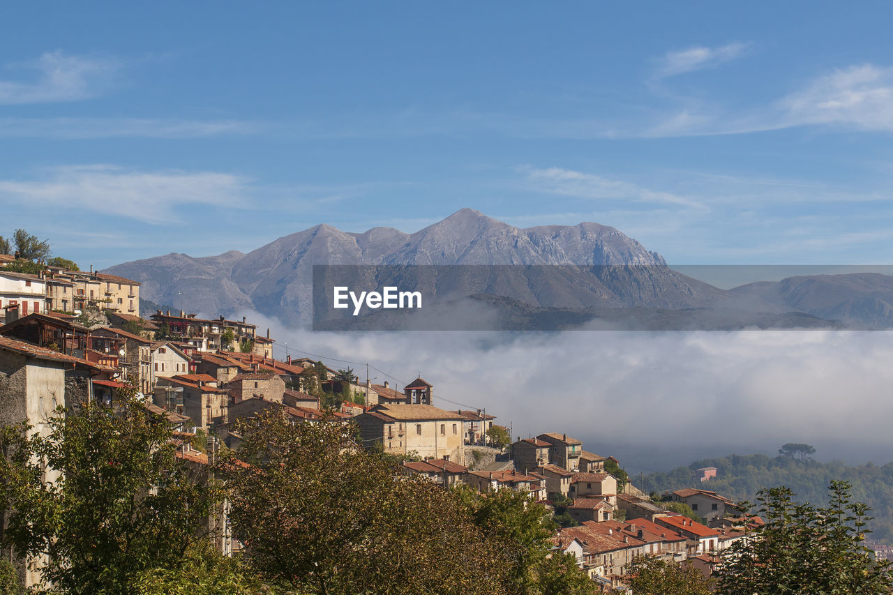 Town by mountain against sky