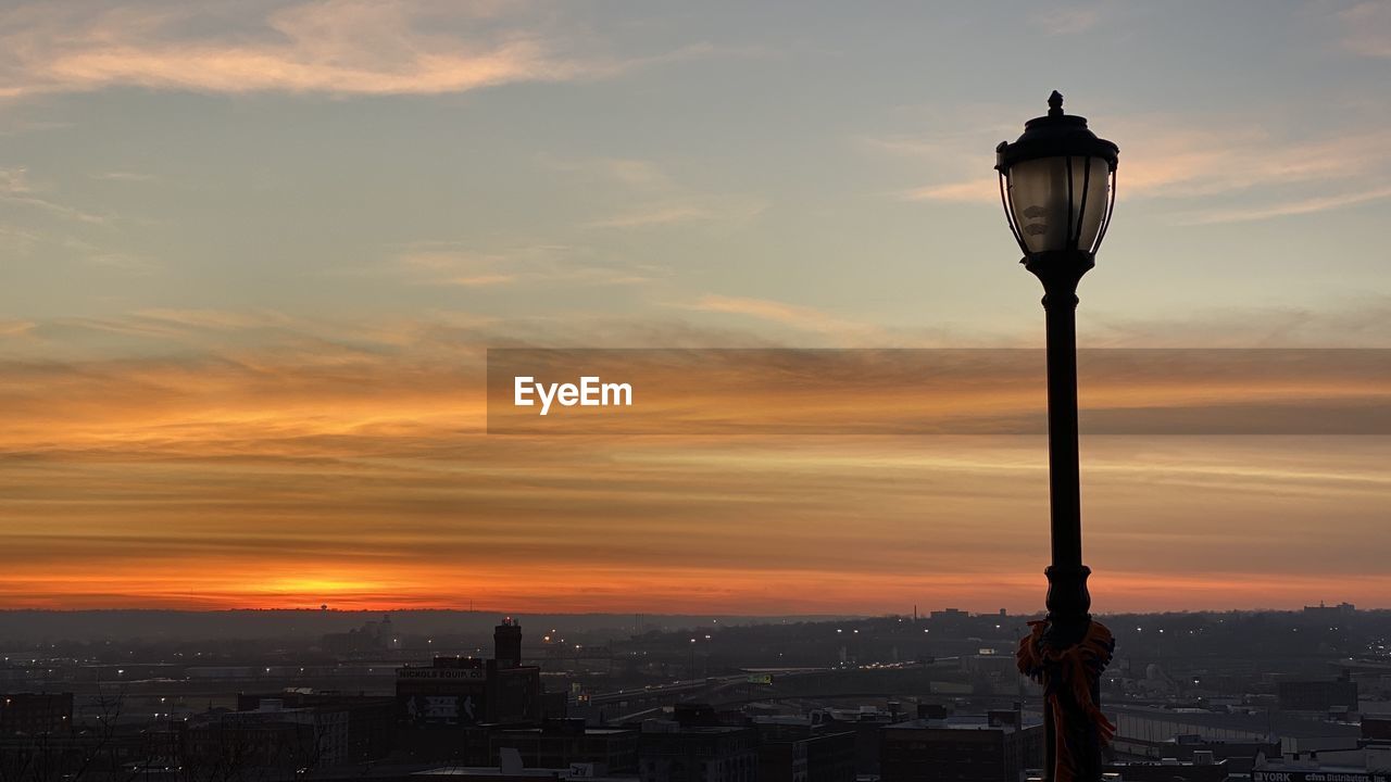 Street light and buildings against colorful skies  during sunset