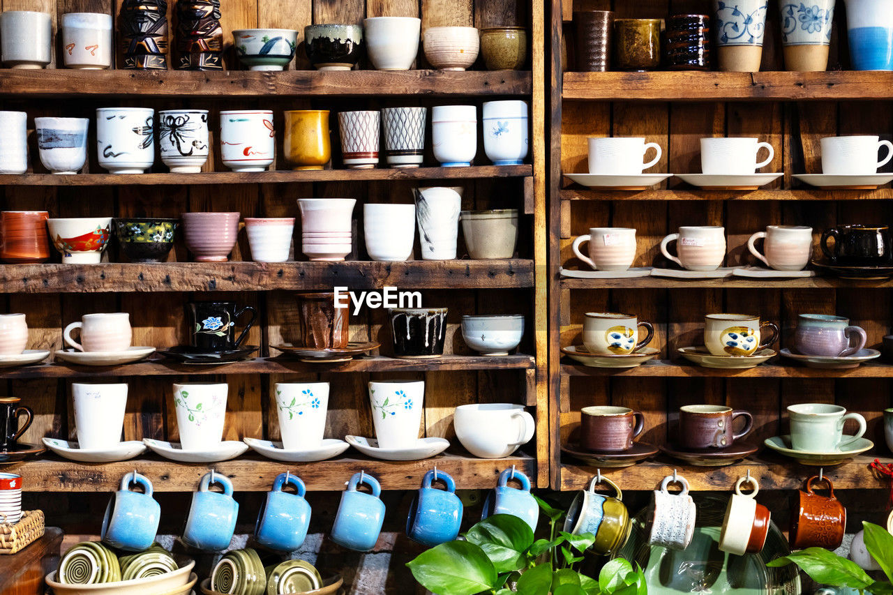 Small store with many pottery ceramic standing on shelves.