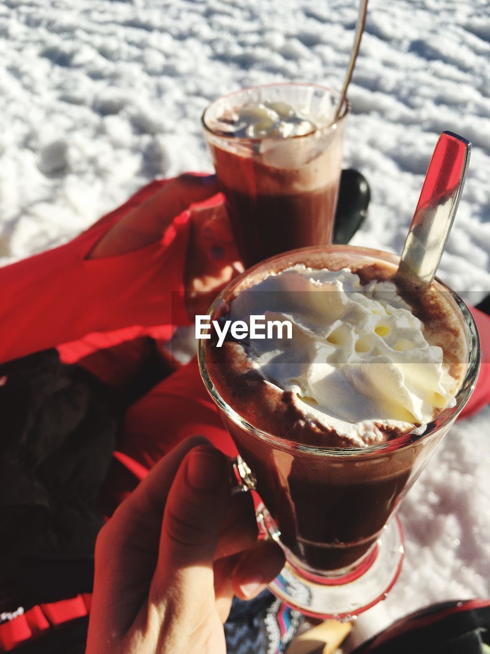 CLOSE-UP OF HAND HOLDING ICE CREAM WITH GLASS OF JUICE