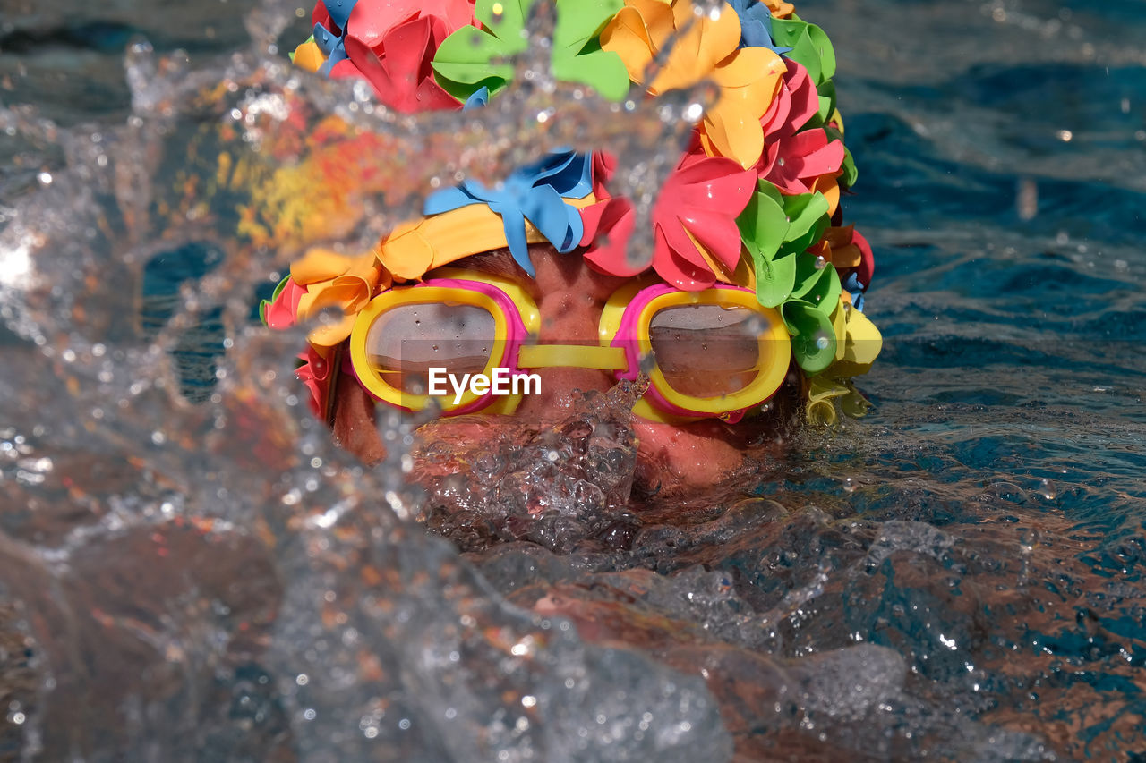 Close-up of man wearing swimming goggles while swimming in sea