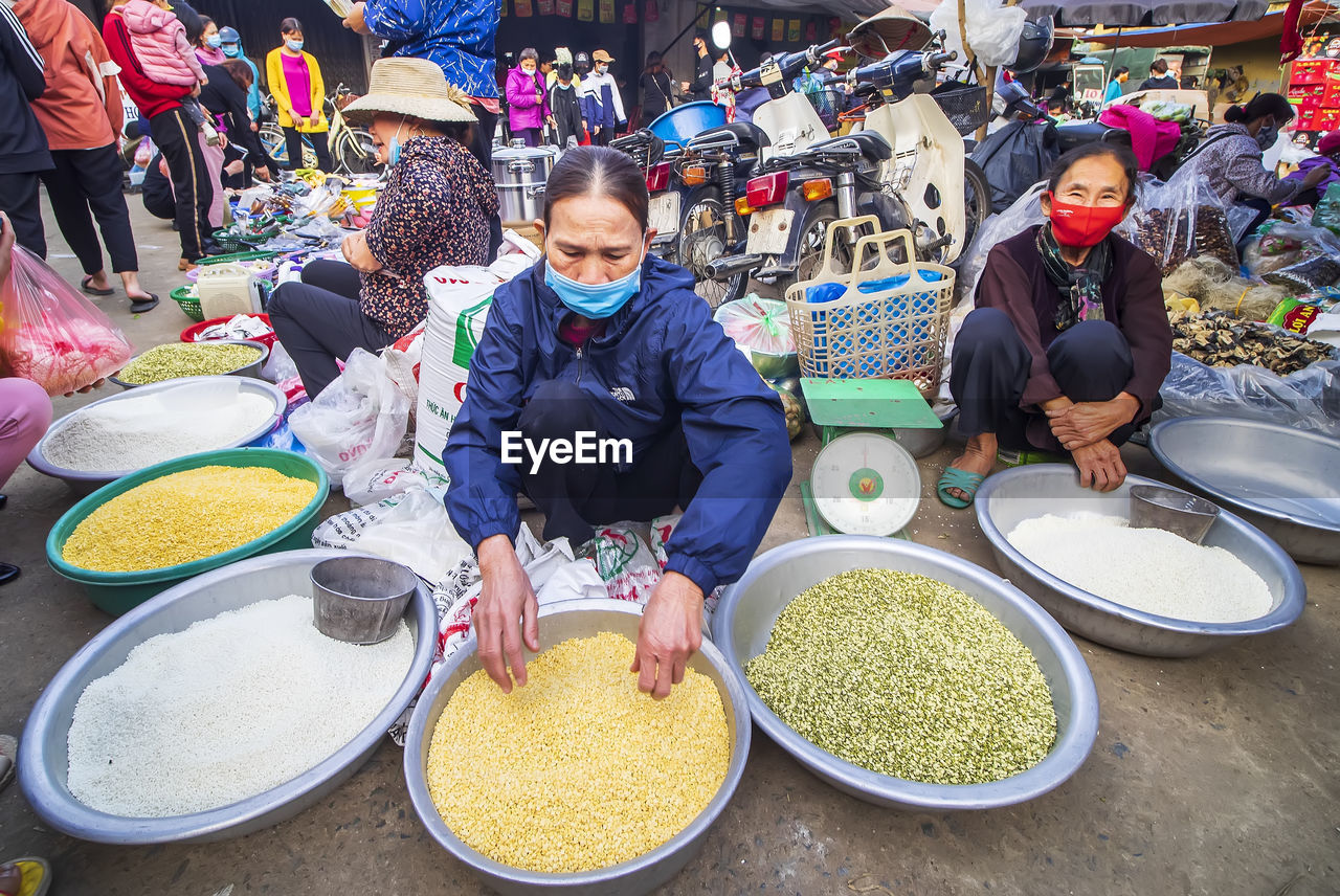 HIGH ANGLE VIEW OF PEOPLE FOR SALE AT MARKET STALL