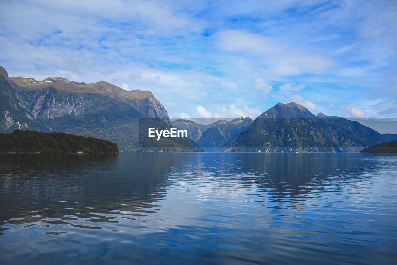 LAKE BY MOUNTAINS AGAINST SKY