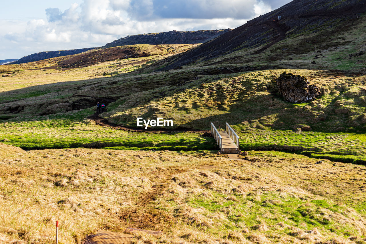 SCENIC VIEW OF FIELD AGAINST MOUNTAINS