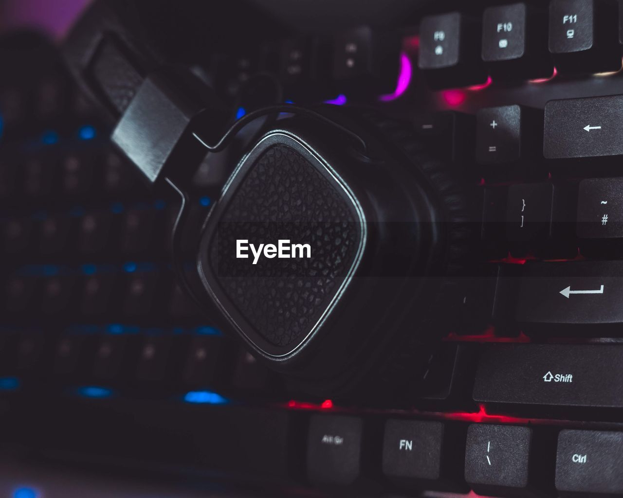 Close-up of headphones over computer keyboard