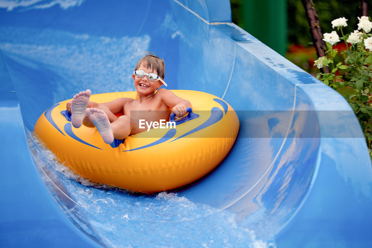 Portrait of cute boy sitting on inflatable ring