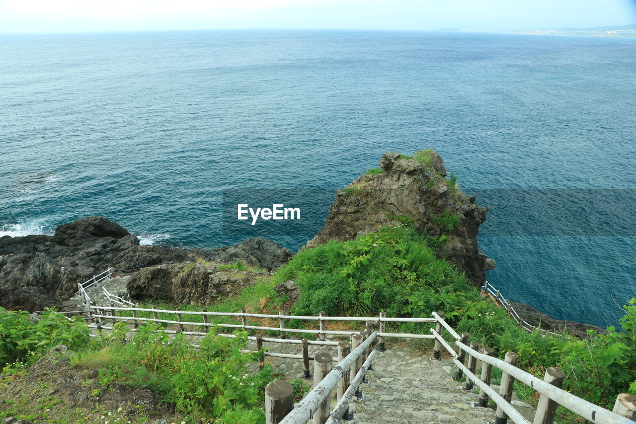 water, sea, scenics - nature, beauty in nature, tranquil scene, tranquility, coast, nature, land, horizon over water, day, railing, high angle view, horizon, plant, no people, sky, idyllic, non-urban scene, beach, cliff, shore, ocean, outdoors, architecture, built structure, bay, vacation, rock, tree, rock formation, promontory