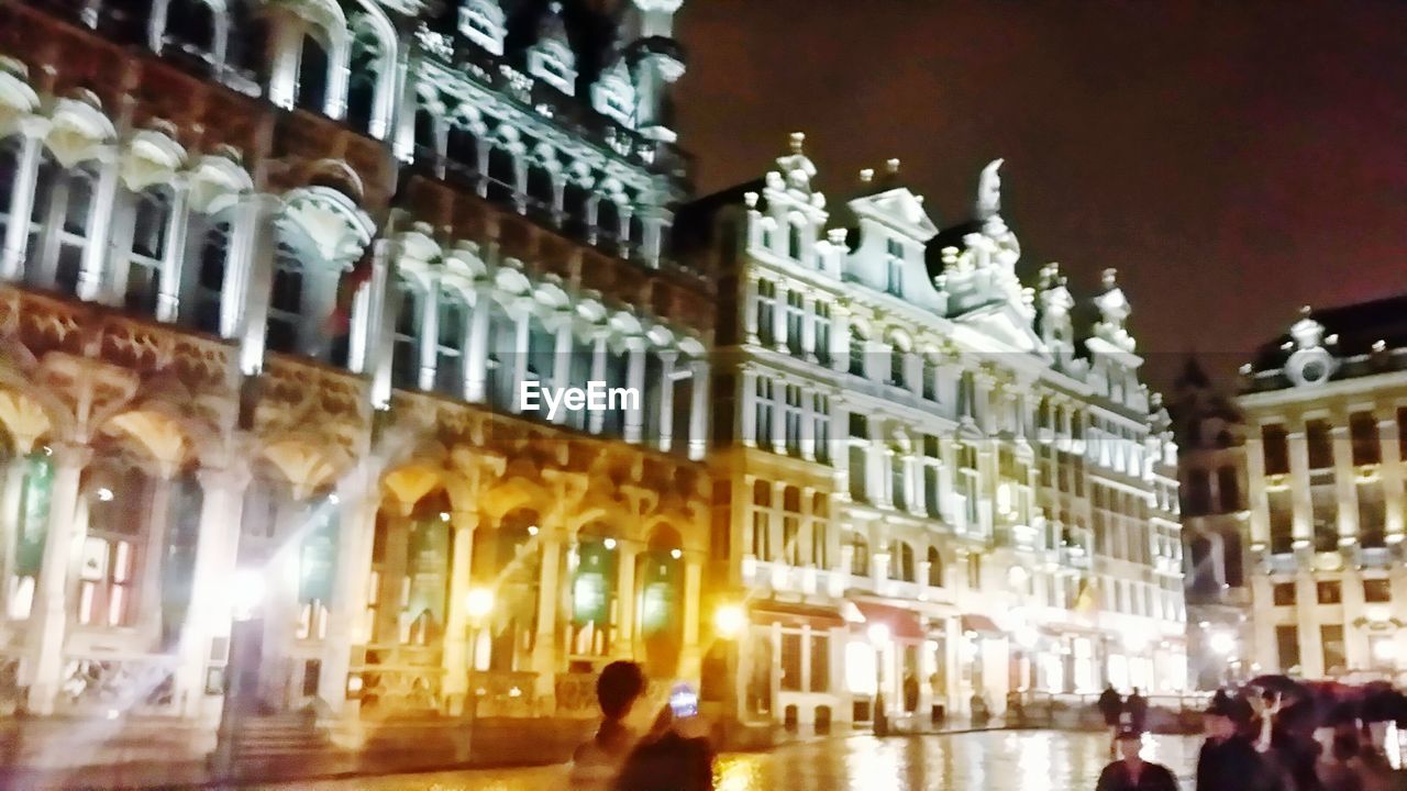 VIEW OF ILLUMINATED CITY STREET AT NIGHT