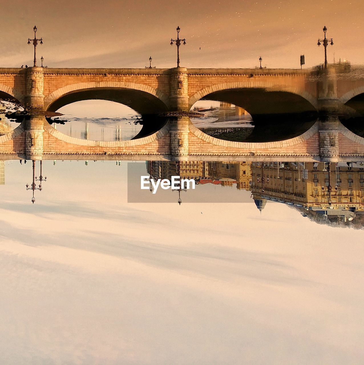 Bridge over river against sky during sunset