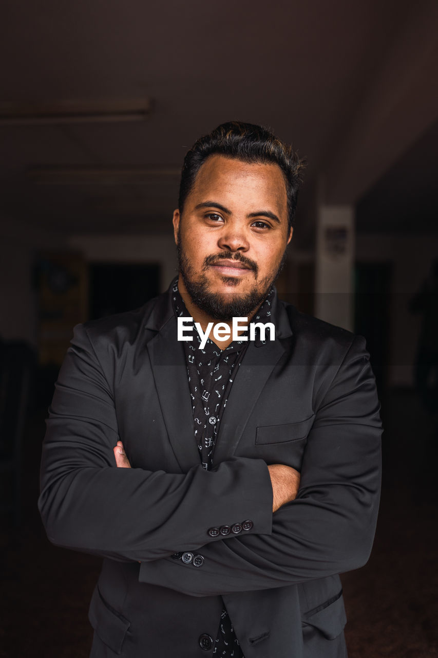 Self assured black male with beard in elegant suit standing looking at camera