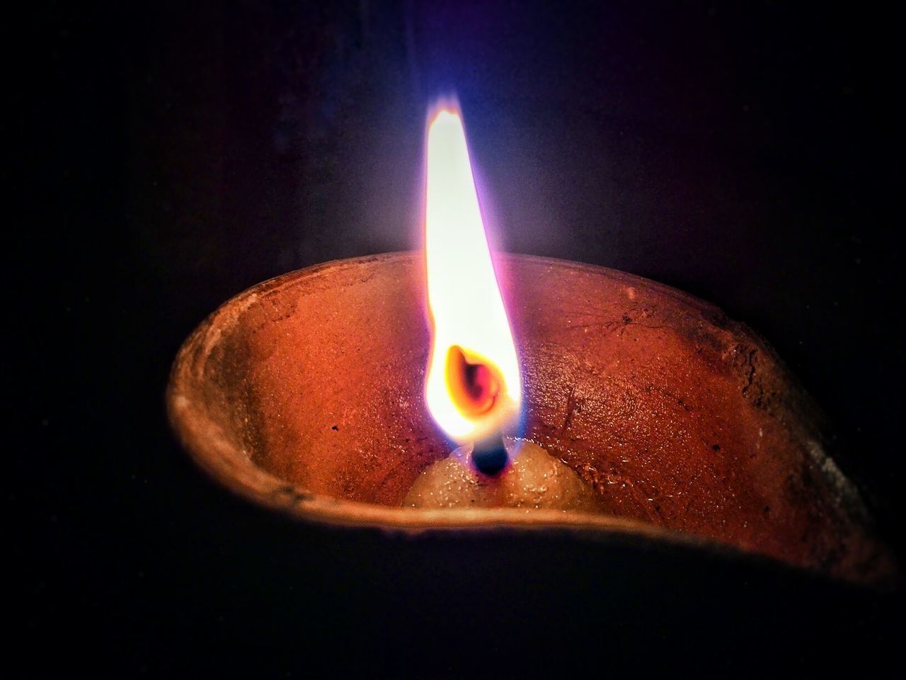 Close-up of diya burning in darkroom