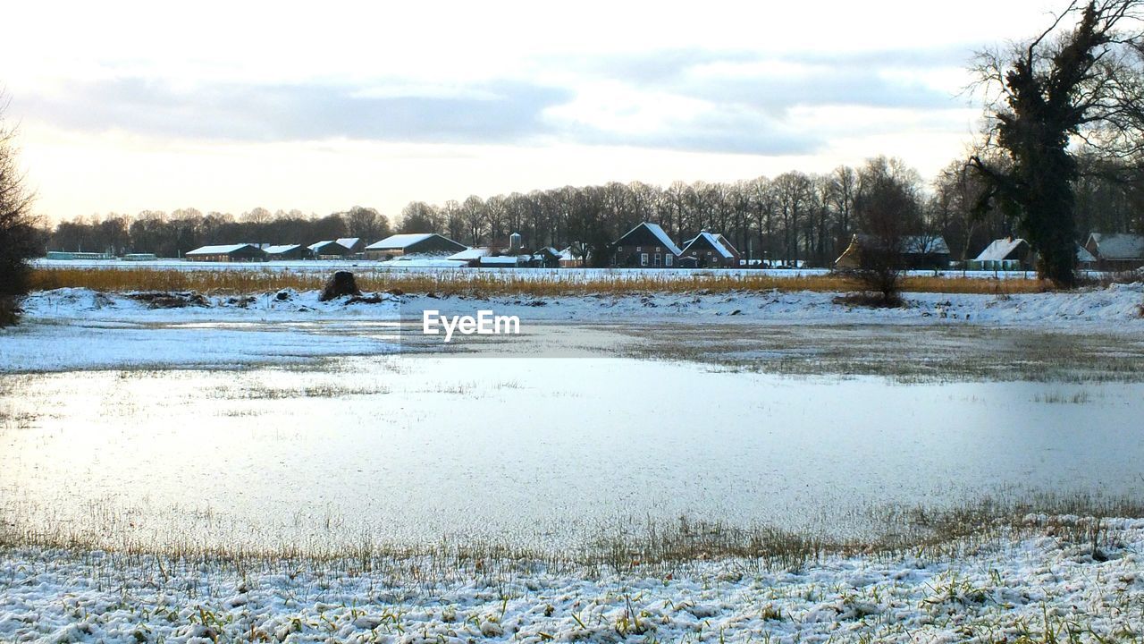 SCENIC VIEW OF FROZEN LAKE AGAINST SKY