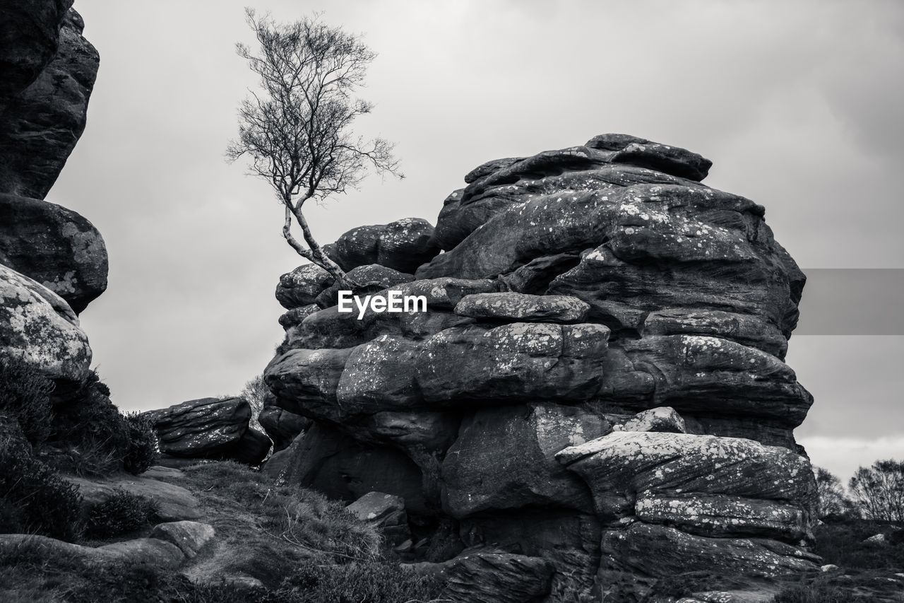 rock, monochrome, black and white, sky, monochrome photography, nature, tree, cloud, mountain, boulder, no people, rock formation, land, landscape, environment, outdoors, plant, beauty in nature, geology, tranquility, scenics - nature, day, non-urban scene, low angle view, travel destinations, black, wilderness, travel, physical geography, balance