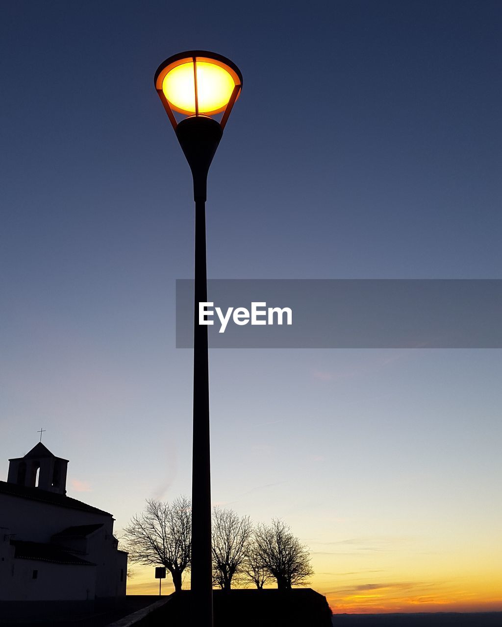 LOW ANGLE VIEW OF ILLUMINATED STREET LIGHT AGAINST SKY AT NIGHT