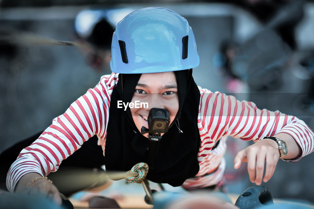 High angle portrait of woman with wearable camera climbing mountain