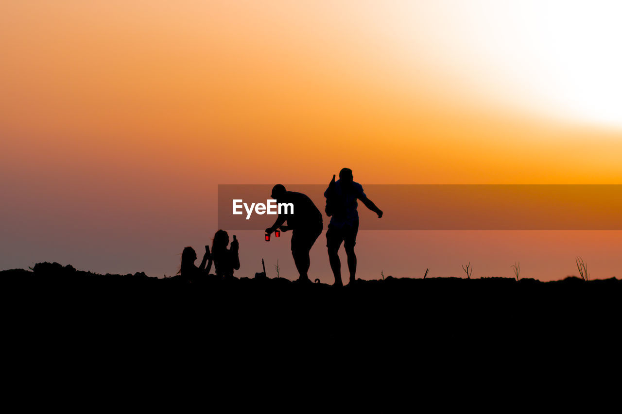 SILHOUETTE PEOPLE ON FIELD AGAINST SKY DURING SUNSET