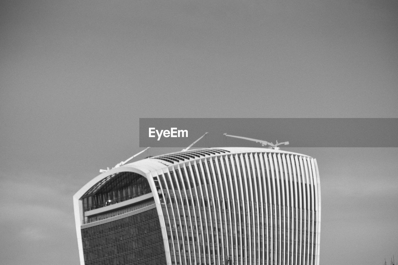 LOW ANGLE VIEW OF METAL AGAINST BUILDING AGAINST SKY