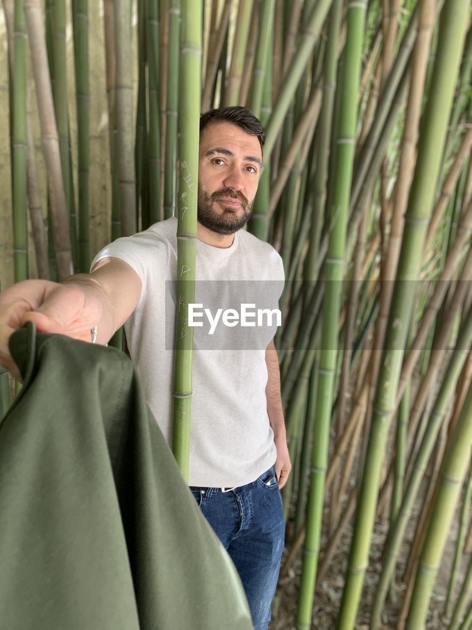 Portrait of man standing amidst bamboo plants