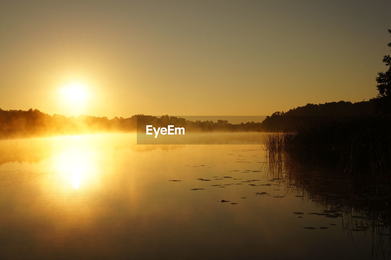 Scenic view of lake against sky during sunrise