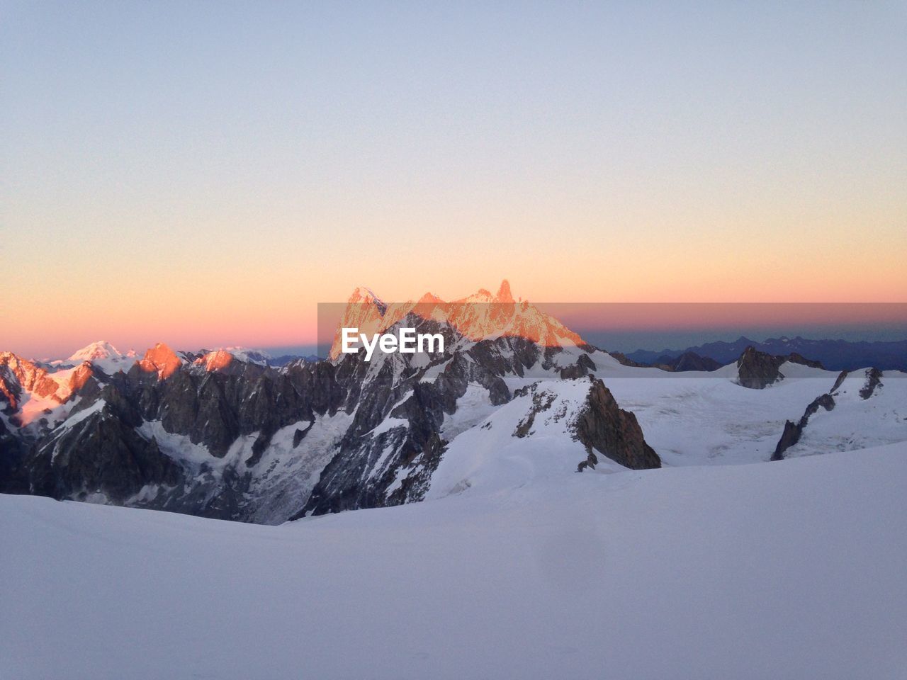 scenic view of snowcapped mountain against clear sky during sunset