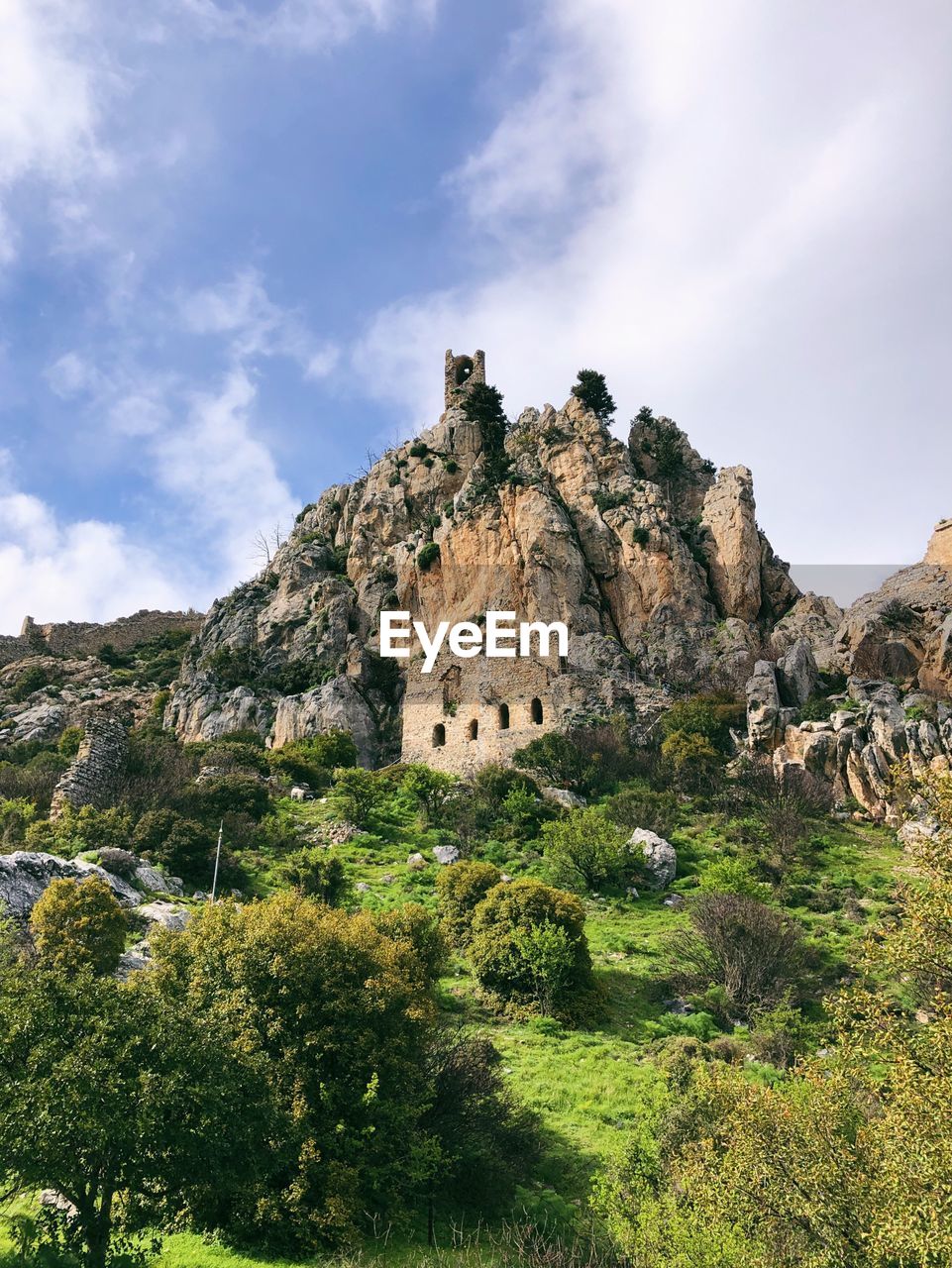 BUILT STRUCTURE ON ROCKS BY MOUNTAIN AGAINST SKY