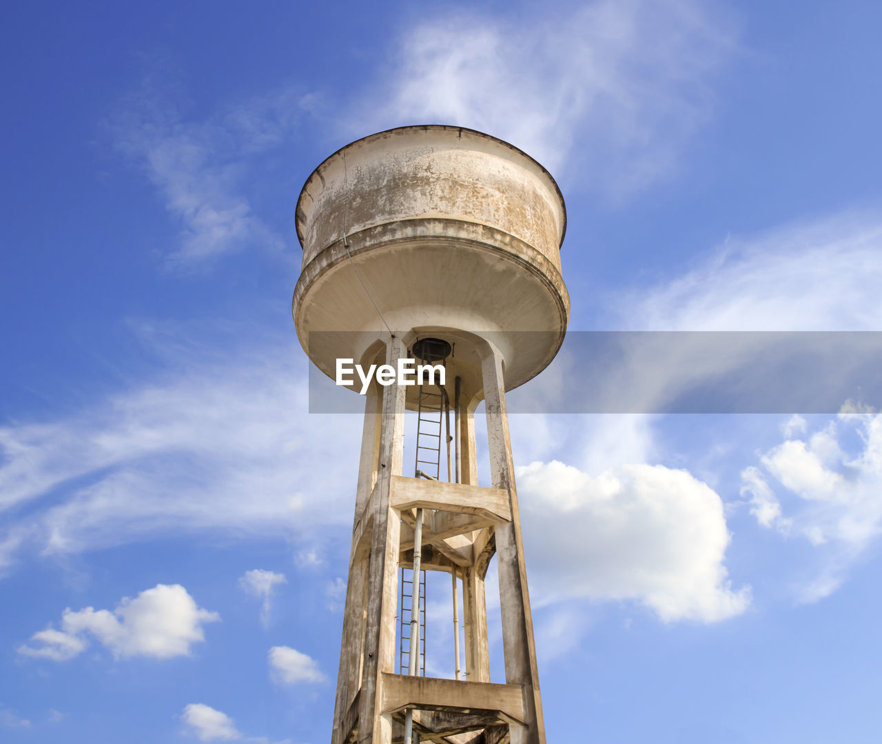 Water tower painted white under blue sky