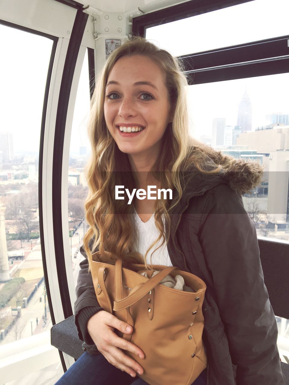 Portrait of happy young woman traveling in overhead cable car