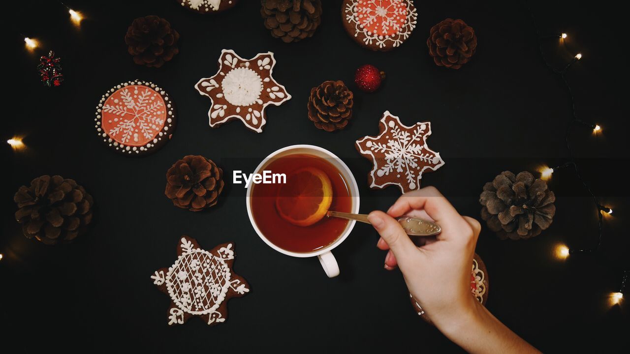 Cropped image of woman holding coffee cup on table