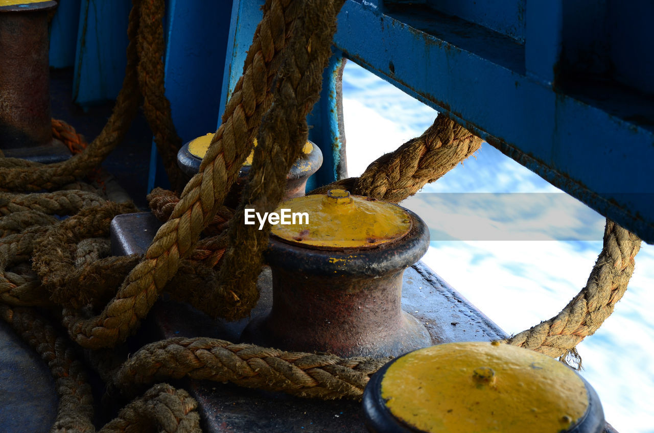 CLOSE-UP OF ROPE TIED UP ON METAL