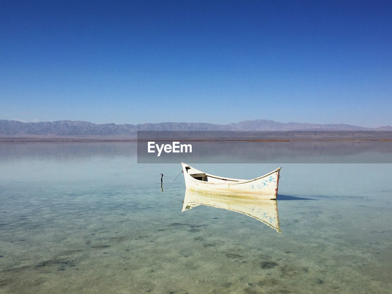 Boat moored in lake against clear sky