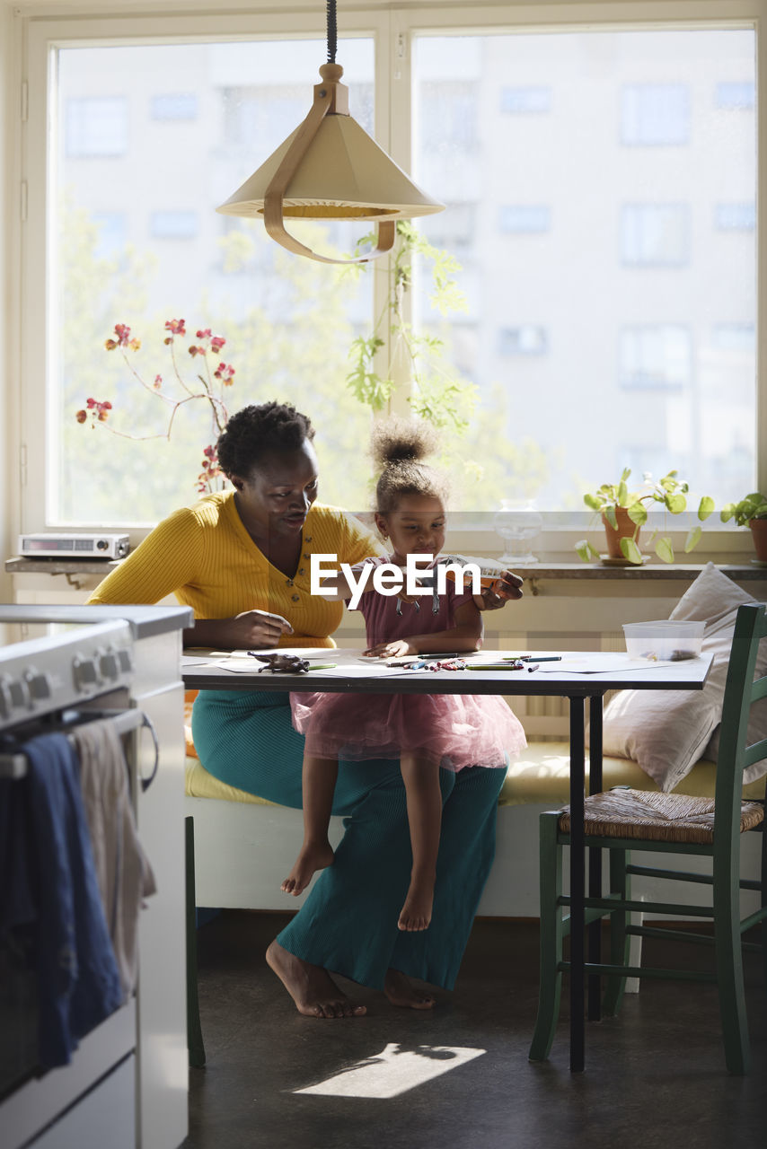 Mother and daughter sitting together at table