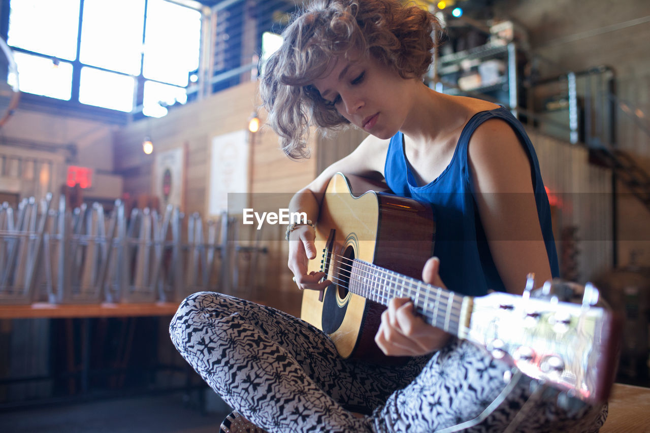 Young woman playing an acoustic guitar