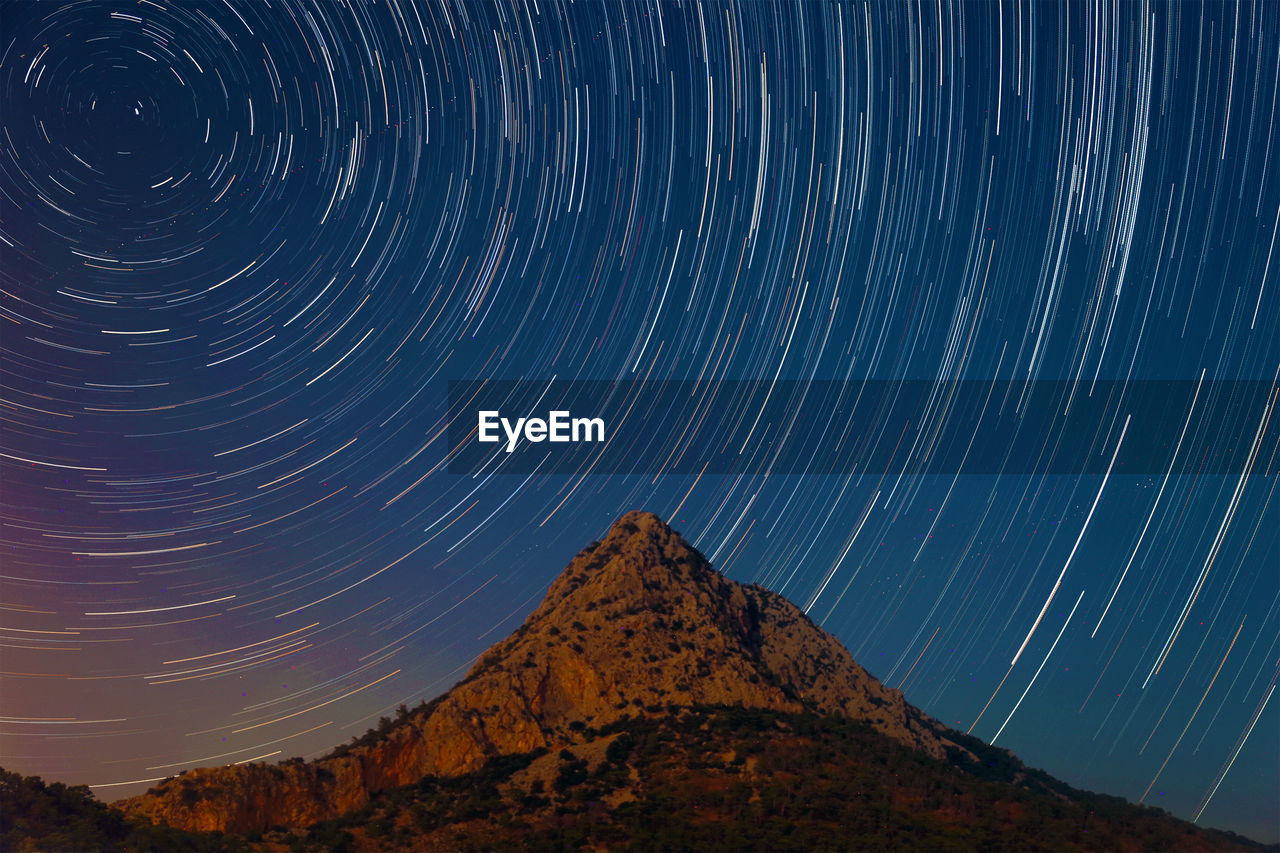 Low angle view of star trails in sky at night