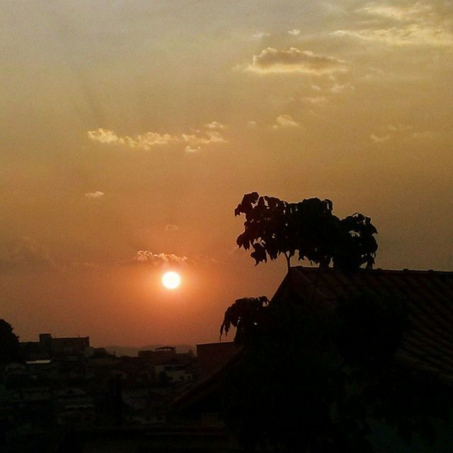 SUN SHINING THROUGH CLOUDS AT SUNSET