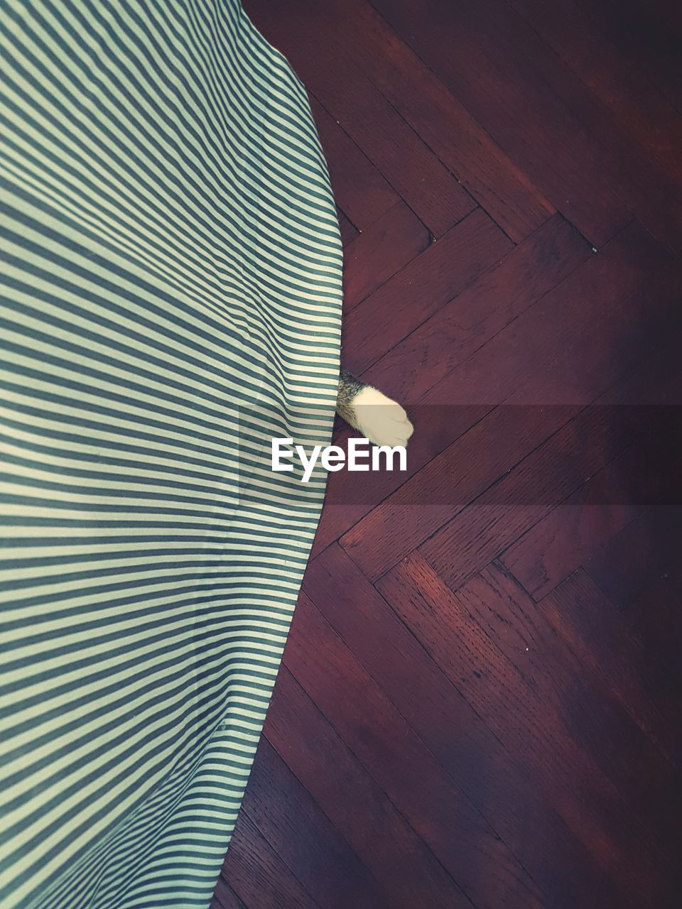 Close-up of curtain hanging over hardwood floor