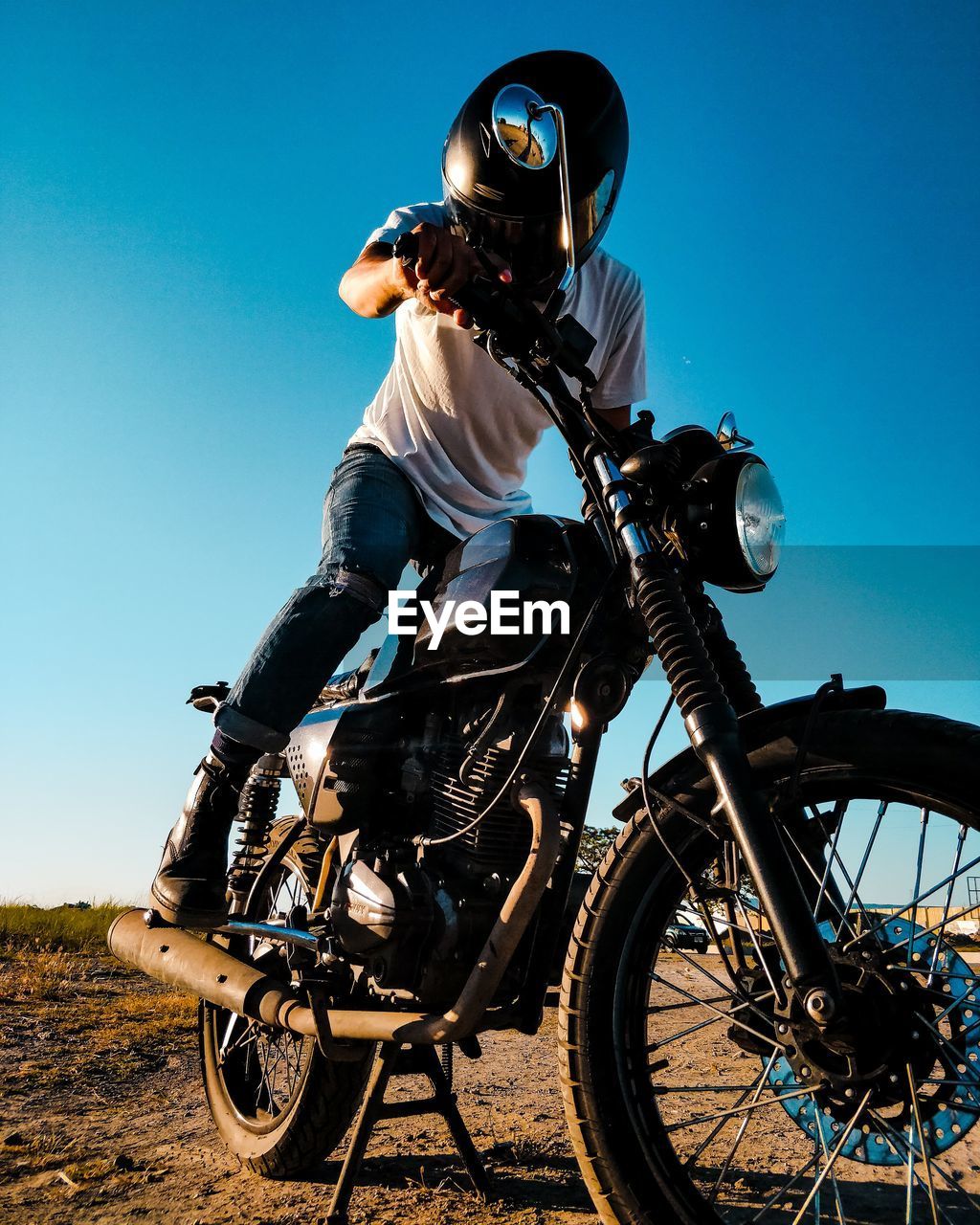 Low angle view of man sitting on motorcycle against sky