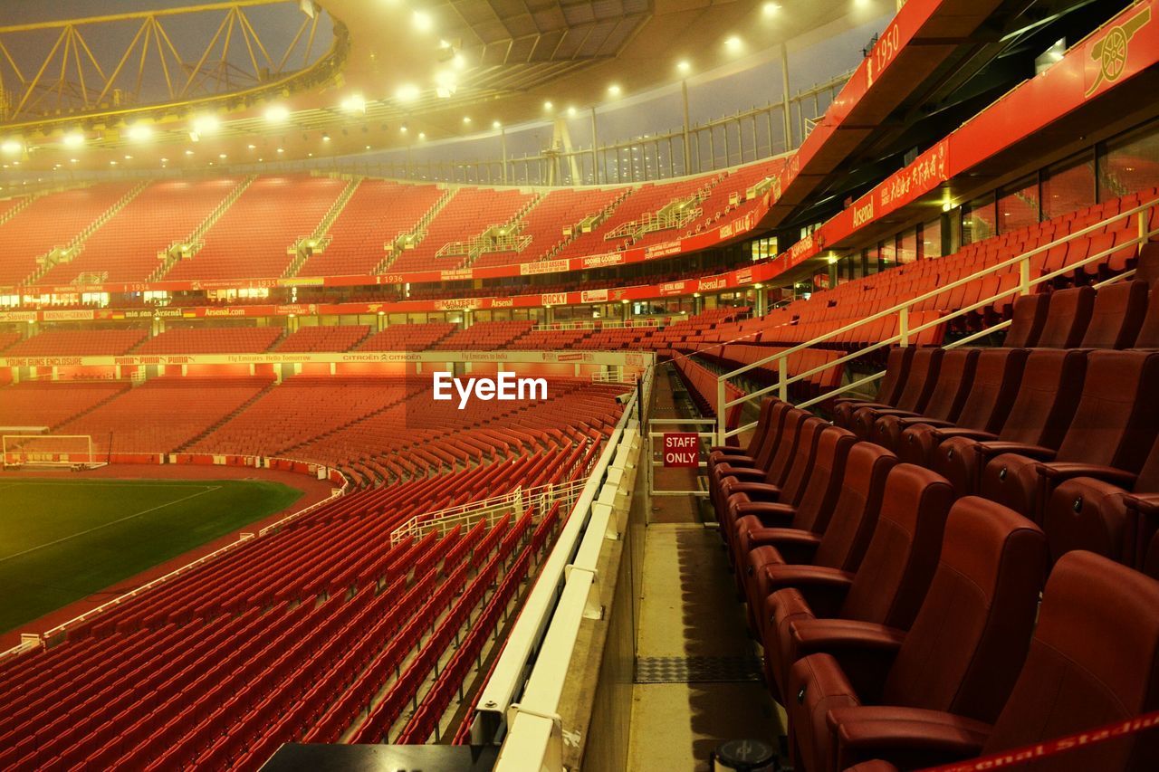 Empty seats in illuminated stadium at night